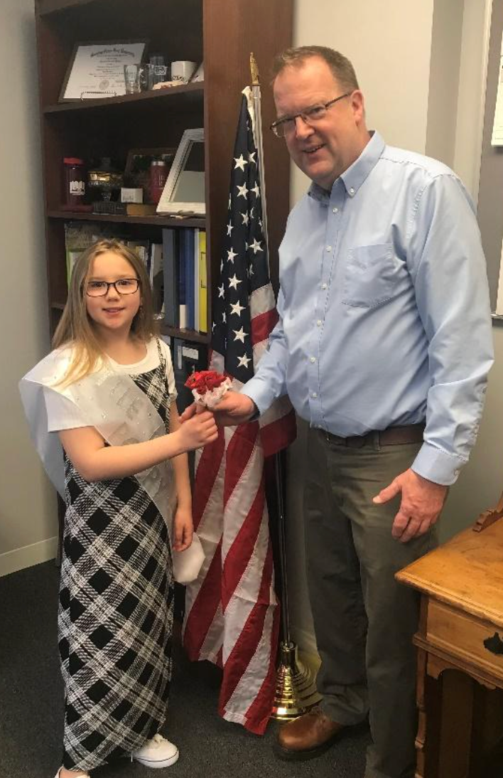 Little Miss Poppy 2024 Riley Spark presenting Orrville Mayor Matt Plybon with his very own poppy.