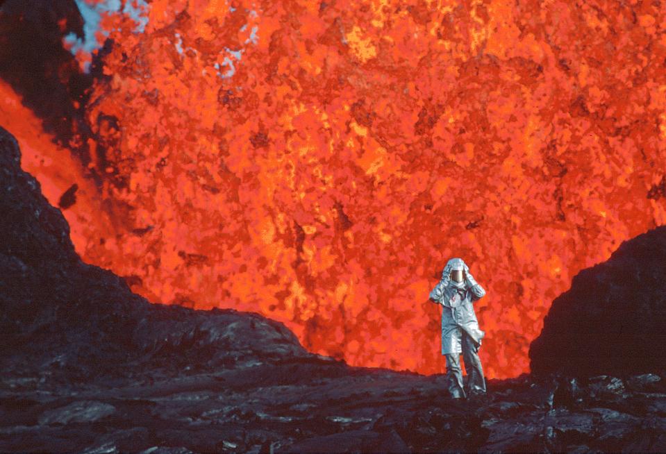 Katia Krafft wearing an aluminized suit as she stands near a lava burst at the Krafla volcano in Iceland.