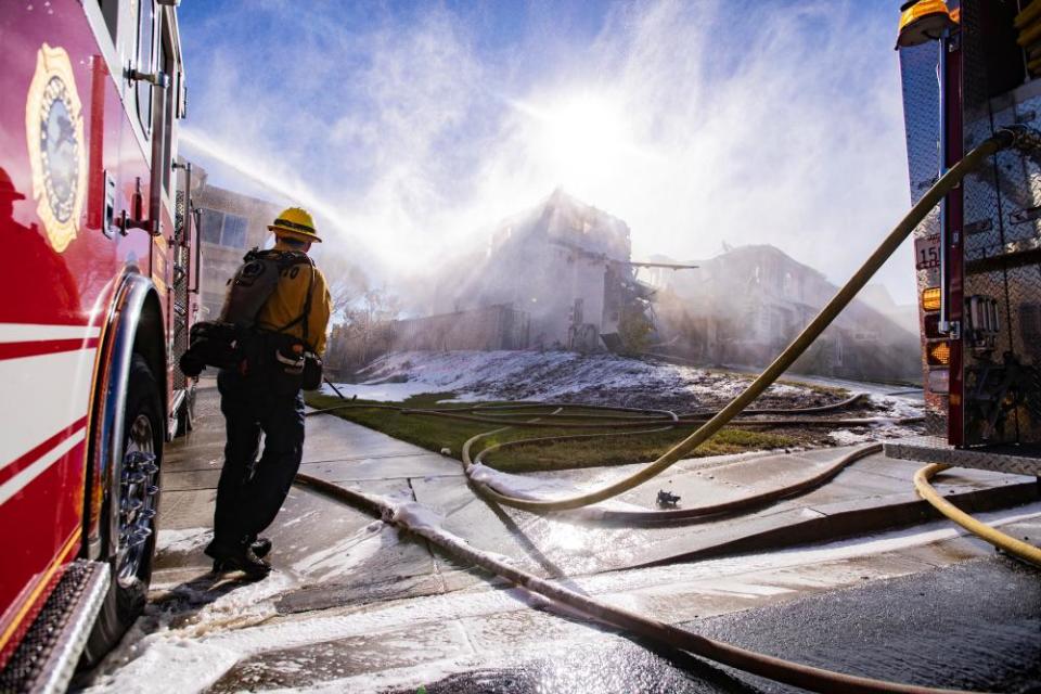 Firefighters extinguish a house set aflame by the Tick fire.