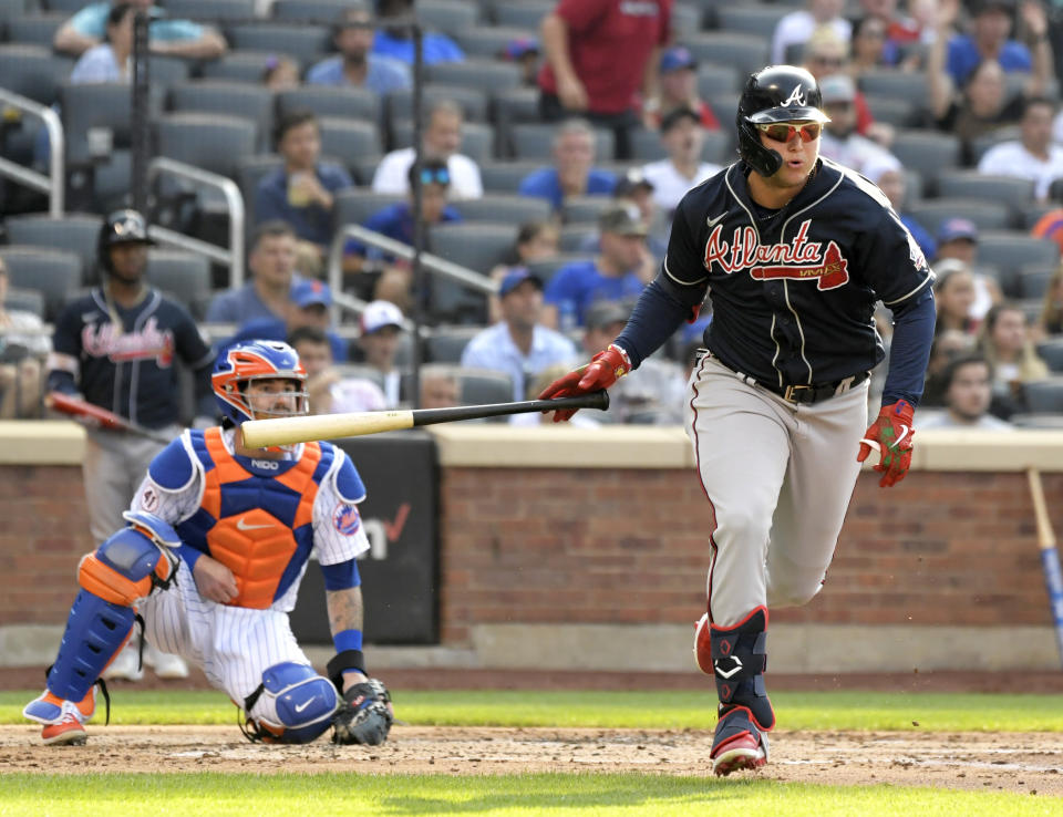 Atlanta Braves' Joc Pederson, right, hits an RBI-double scoring Guillermo Heredia as New York Mets catcher Tomas Nido, left, looks on during the third inning of the first game of a baseball doubleheader Monday, July 26, 2021, in New York. (AP Photo/Bill Kostroun)