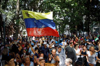 <p>People hold a national flag while gathering at a polling station during an unofficial plebiscite against Venezuela’s President Nicolas Maduro’s government and his plan to rewrite the constitution, in Caracas, Venezuela July 16, 2017. (Carlos Garcia Rawlins/Reuters) </p>