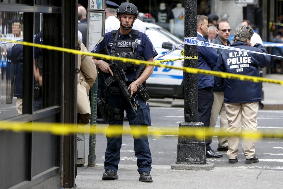 Members of the NYPD police stand near the crime scene at the intersection of 37th street and 8th avenue in midtown Manhattan in New York