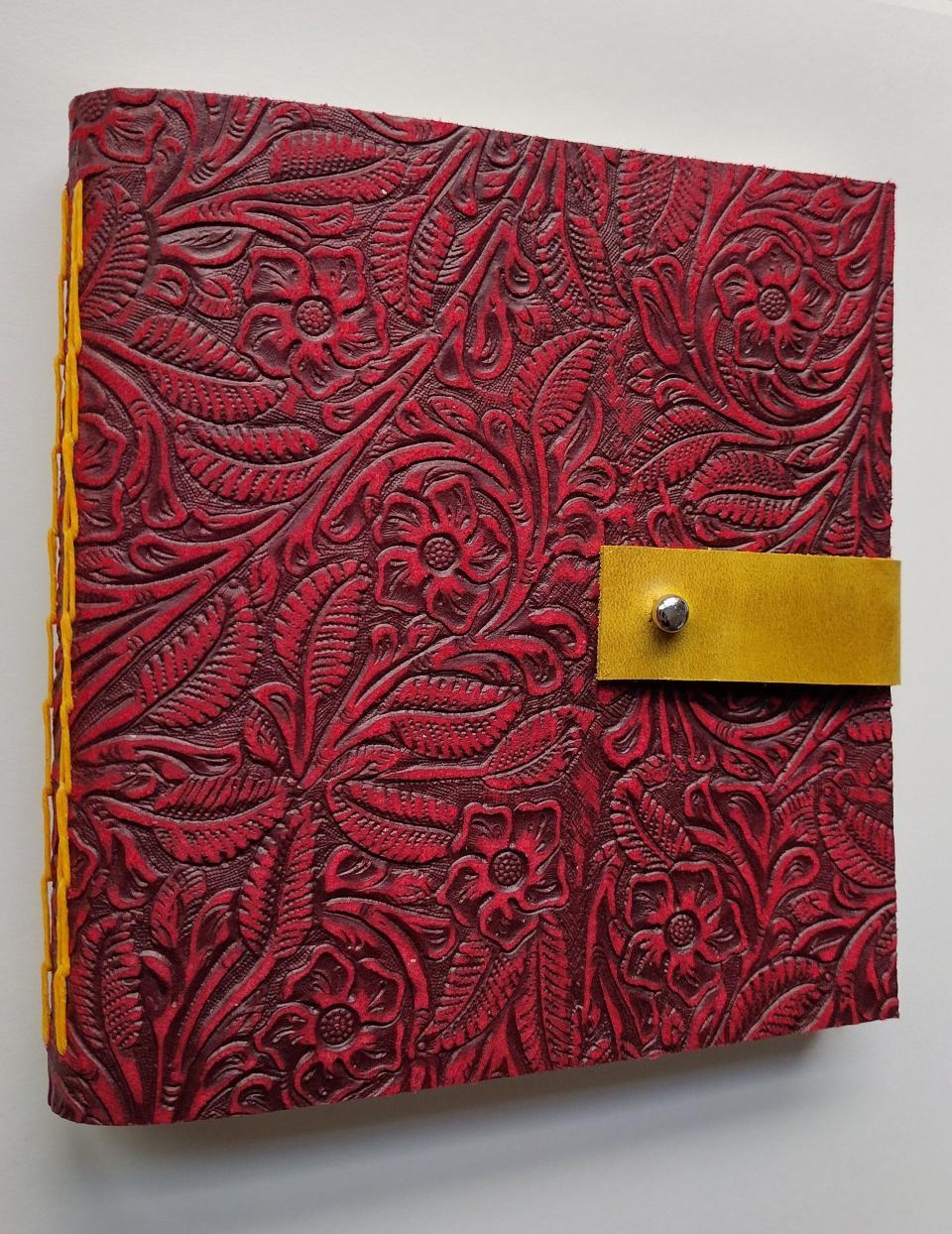 A tooled leather journal with chain-link stitch binding by Tina Egnoski's business Wordlily.