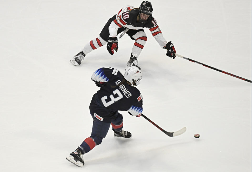 United States' Cayla Barnes scores a goal as Canada's Sarah Fillier, top defends in the first period of a women's hockey game in a pre-Olympic Games series Monday, Oct. 25, 2021, in Hartford, Conn. (AP Photo/Jessica Hill)