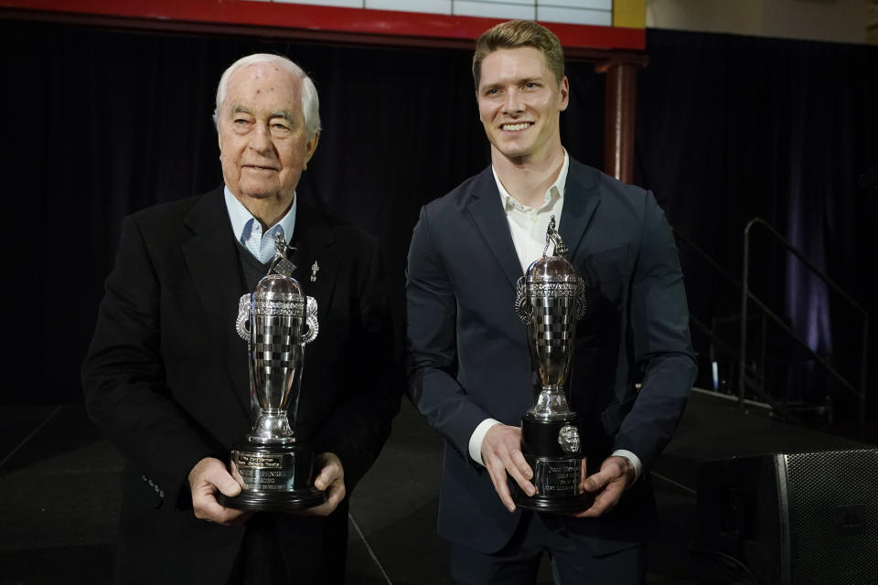 Roger Penske, team owner, left, and driver Josef Newgarden, winner of the 2023 Indianapolis 500, hold their Baby Borg team owner's and driver's trophies, Tuesday, Jan. 23, 2024 in Dearborn, Mich. (AP Photo/Carlos Osorio)