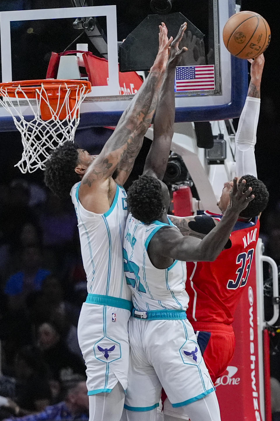 Charlotte Hornets center Nick Richards, left, and forward JT Thor try to block a shot by Washington Wizards forward Kyle Kuzma during the first half of an NBA basketball game Friday, March 8, 2024, in Washington. (AP Photo/Alex Brandon)