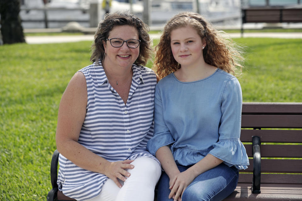 In this Friday, April 10, 2020, photo, Ebru Ural, left, and her daughter Serra Sowers pose while discussing choosing colleges without actually visiting them at a park in Sanford, Fla. The coronavirus pandemic has changed the process of college visits to virtual interviews and visits. (AP Photo/John Raoux)