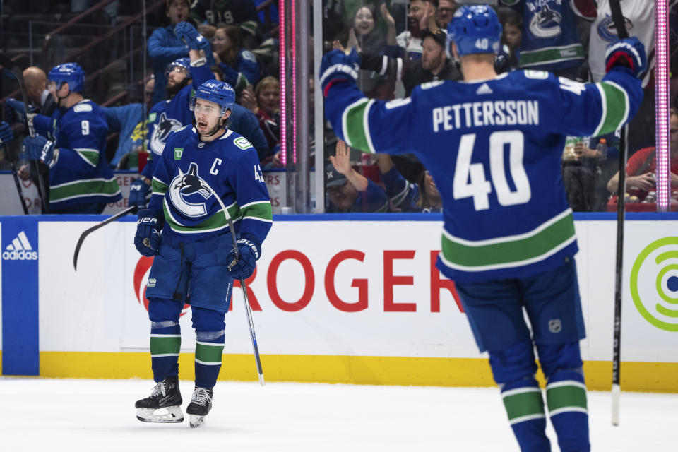 Vancouver Canucks' Quinn Hughes (43) celebrates his goal against the Seattle Kraken as Elias Pettersson (40) cheers during the second period of an NHL hockey game Saturday, Nov. 18, 2023, in Vancouver, British Columbia. (Ethan Cairns/The Canadian Press via AP)