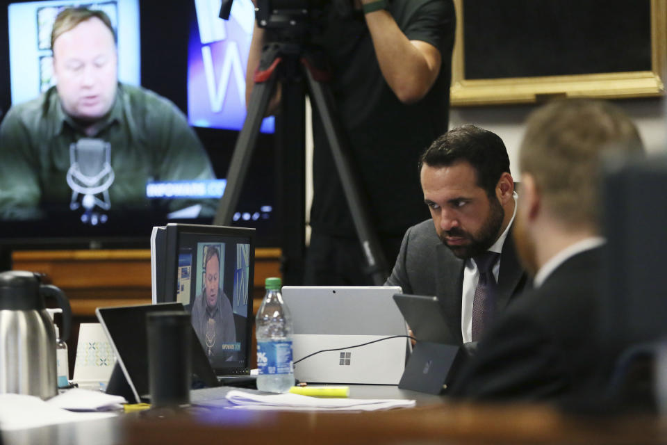 Bill Ogden, partner with the firm representing Neil Heslin and Scarlett Lewis, parents of parents of Sandy Hook shooting victim Jesse Lewis, reacts while watching a clip from InfoWars during the trial for Alex Jones Thursday, July 28, 2022. (Briana Sanchez/Austin American-Statesman via AP, Pool)