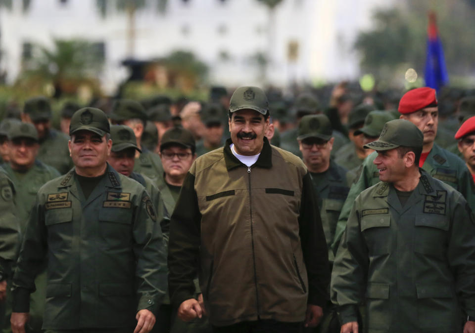 In this handout photo released by Miraflores Press Office, Venezuela's President Nicolas Maduro, center, accompanied by Defense Minister Gen. Vladimir Padrino Lopez, left, and the Strategies Operations Commander, Adm. Remigio Ceballos, arrive for a meeting with the troops at Fort Tiuna in Caracas, Venezuela, Thursday, May 2, 2019. (Jhonn Zerpa/Miraflores Press Office via AP)