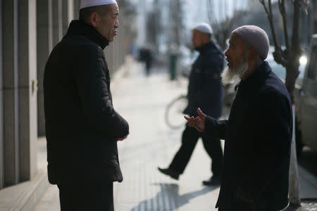 Men talk on a street in China's Linxia, Gansu province, home to a large population of ethnic minority Hui Muslims, February 3, 2018. Picture taken February 3, 2018. REUTERS/Michael Martina