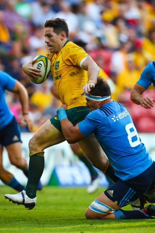 Bernard Foley of Australia is tackled by Andries Van Schalkwyk of Italy during their rugby union Test match, at Suncorp Stadium in Brisbane, on June 24, 2017