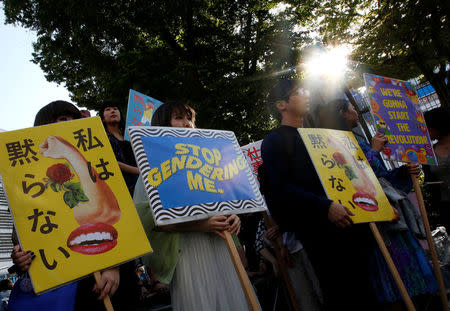 Protesters hold placards during a rally against harassment at Shinjuku shopping and amusement district in Tokyo, Japan, April 28, 2018. Picture taken April 28, 2018. REUTERS/Issei Kato