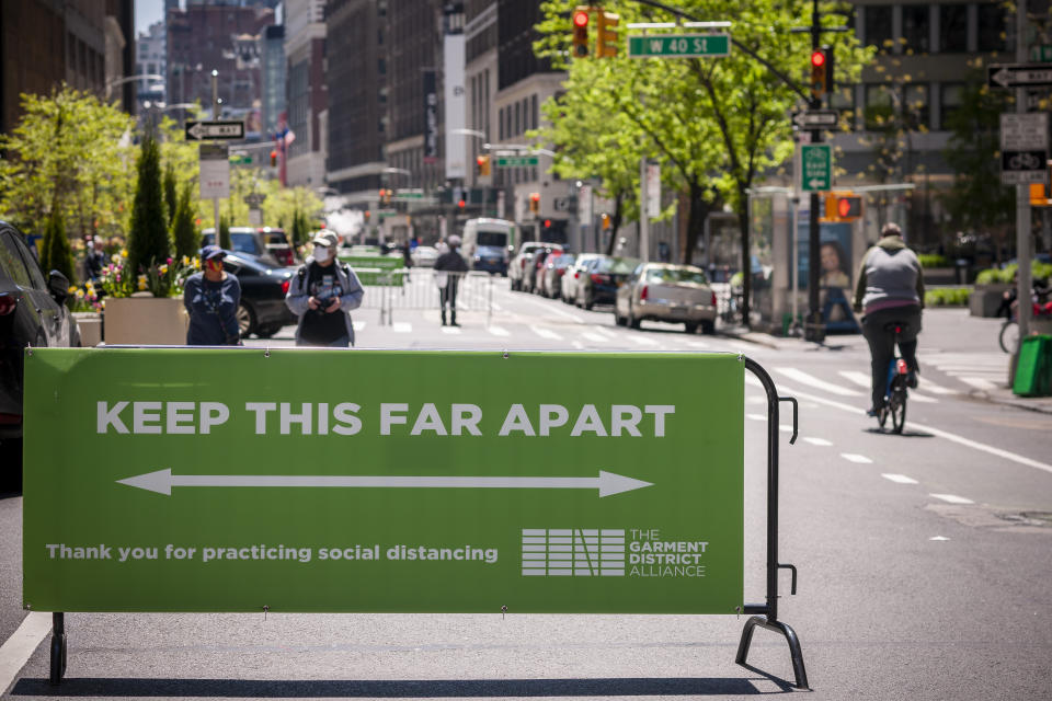 A sign reminds people of social distancing on the closed to traffic Broadway in the Garment District in New York. Source: AAP