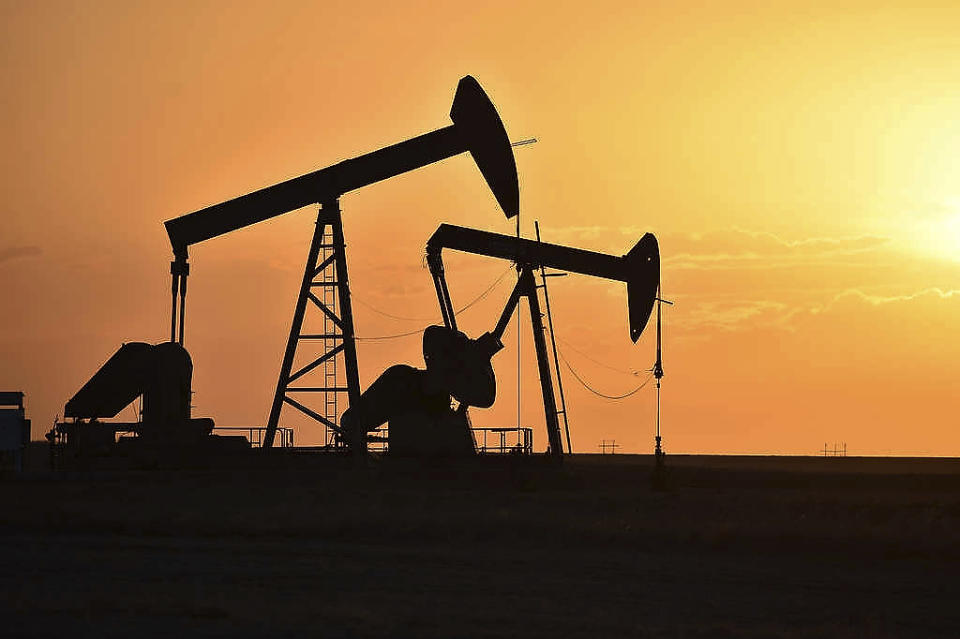 In this Wednesday, May 19, 2021, photo, pump jacks extract oil from beneath the ground on the Fort Berthold Indian Reservation east of New Town, North Dakota. On oil well pads carved from the wheat fields around Lake Sakakawea, hundreds of pump jacks slowly bob to extract 100 million barrels of crude annually from a reservation shared by three Native American tribes.  (AP Photo/Matthew Brown)