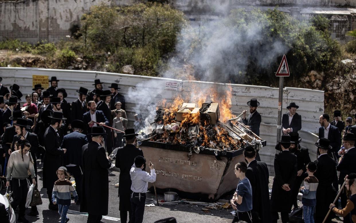 Jewish people light fires fires and cut off bread and other foodstuffs made from yeast hours before the start of the Jewish holiday of Passover in Jerusalem