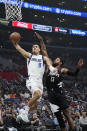 Dallas Mavericks guard Josh Green, left, shoots as Los Angeles Clippers forward Paul George defends during the first half of an NBA basketball game Wednesday, Feb. 8, 2023, in Los Angeles. (AP Photo/Mark J. Terrill)