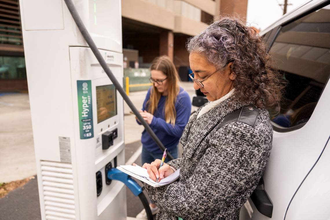 Dahlia Garas, manager of the UC Davis Electric Vehicle Research Center, takes notes earlier this month in downtown Sacramento at an Electrify America station after Erinne Boyd, project manager, was unable to use a credit card. The center is looking into the reliability of electric stations.