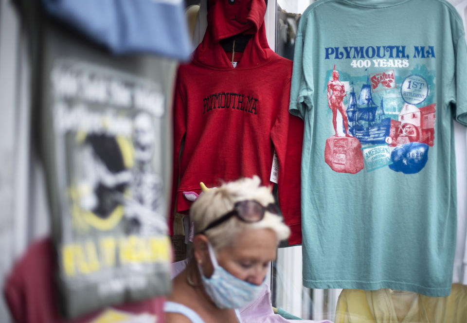 A pedestrian walks past a gift shop in Plymouth, Mass., the traditional point of arrival of the Pilgrims in 1620 on the Mayflower, Wednesday, Aug. 12, 2020. The year 2020 was supposed to be a big one for Pilgrims. Dozens of events, from art exhibits and festivals to lectures and a maritime regatta featuring the Mayflower II, a full-scale replica were planned to mark the 400th anniversary of the religious separatists' arrival at what we now know as Plymouth, Mass. Some historians find it ironic that a pandemic has put many of the 400th anniversary commemorations on hold. (AP Photo/David Goldman)