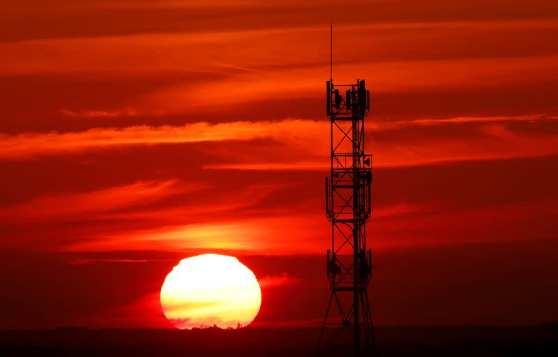 FILE PHOTO: The sun sets behind transmitting antennas on a mobile-phone network relay mast in Vertou