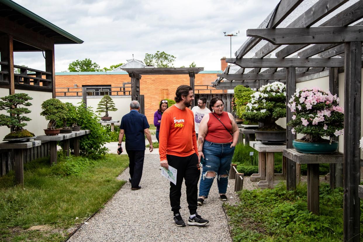 Blake Woods, of Waterford, talks to Emily Sutton, of Canton, as they appreciate the trees at the Bonsai Garden of Matthaei Botanical Gardens in Ann Arbor on Friday, June 7, 2024.