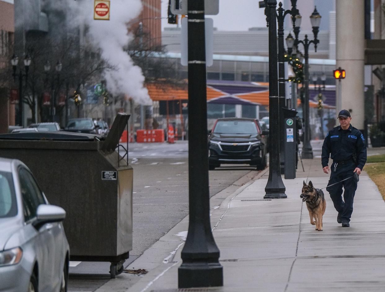 A Michigan State Trooper and his dog walk along Ottawa Street next to the Capitol Wednesday, Jan. 3, 2024. The Capitol was evacuated earlier because of a threat.