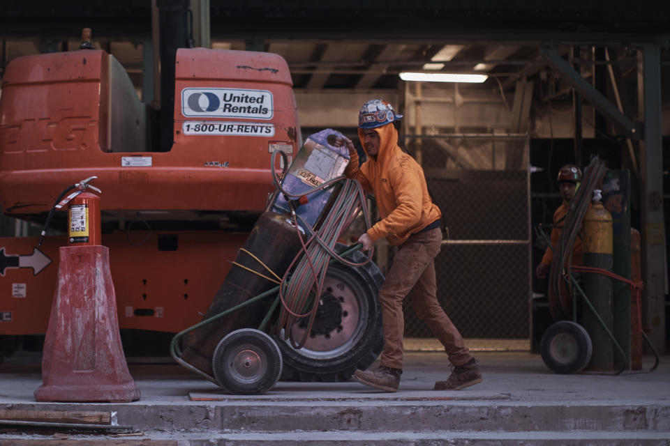 Construction workers handle equipment on Tuesday, Jan. 17, 2023, in New York. After the relative quiet of the pandemic, New York City has come roaring back. Just listen: Jackhammers disrupt the peace and fleets of honking cars, trucks and buses again clog thoroughfares as millions of denizens return to the streets — their voices and clacking heels adding to the ear-splitting din. In one of the world's noisiest cities, the cacophony has returned louder than ever. (AP Photo/Andres Kudacki)