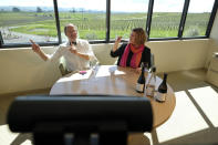 Sales director Brian Allard, left, and winemaker and general manager Chris Kajani lead a live virtual wine tasting with a couple near Reno, Nev., from Bouchaine Vineyards Thursday, March 19, 2020, in Napa, Calif. The winery is presently closed to visitors because of the coronavirus threat, but just started conducting tastings to its customers online. People wanting to taste can select from three different wine tasting kits. The wine included in the kit is shipped to the recipient with instructions on booking an appointment and how to access the virtual contact via the internet. (AP Photo/Eric Risberg)
