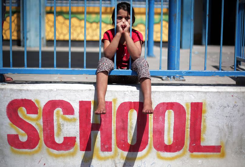 Le 14 juillet 2014, une fillette palestinienne est assise sur le mur de la nouvelle école des Nations Unies de Gaza