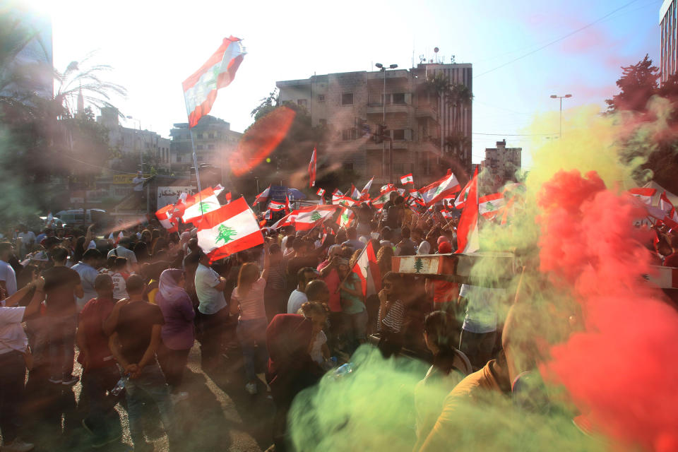 Lebanese protesters wave national flags as they gather in the southern city of Sidon (Saida) on Oct. 19, 2019 for a third day of protests. | Mahmoud Zayyat—AFP via Getty Images