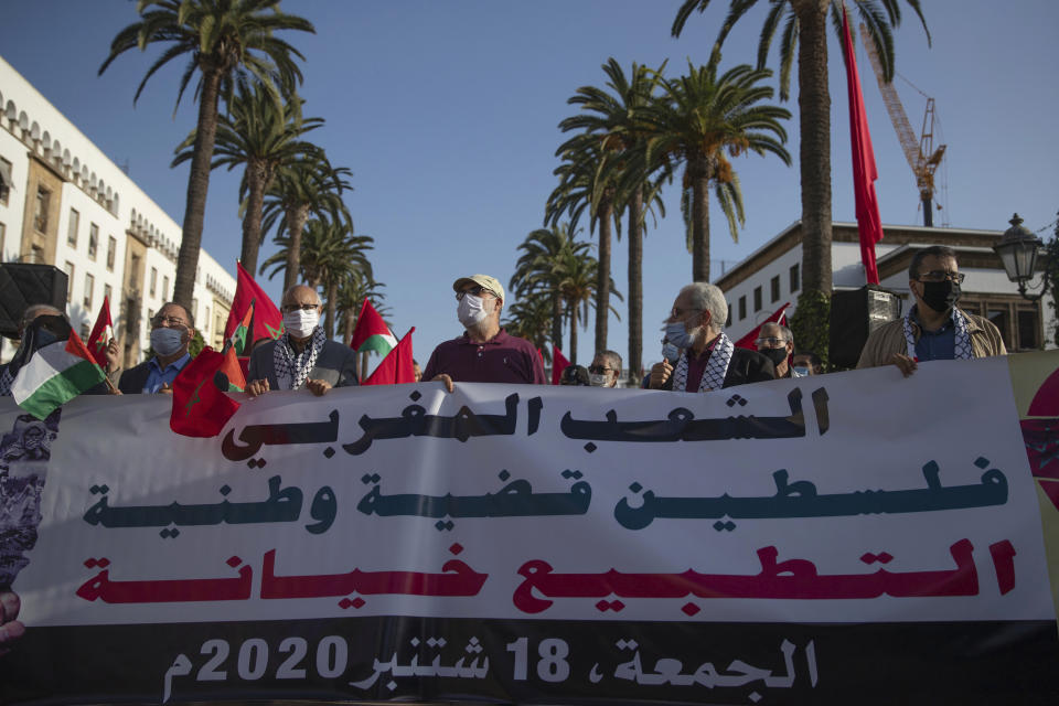 People hold a banner during a protest against normalizing relations with Israel, in Rabat, Morocco, Friday, Sept. 18, 2020. Despite a government ban on large gatherings aimed at preventing the spread of the coronavirus, scores of Moroccans staged a protest outside parliament building in the capital Rabat on Friday to denounce Arab normalization agreements with Israel. Banner in Arabic reads "Palestine is a national cause, normalization is a betrayal." (AP Photo/Mosa'ab Elshamy)