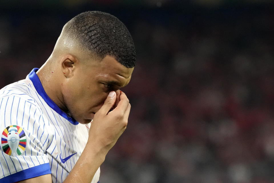 Kylian Mbappe of France holds his nose after suffering an injury during a Group D match between Austria and France at the Euro 2024 soccer tournament in Duesseldorf, Germany, Monday, June 17, 2024. (AP Photo/Martin Meissner)