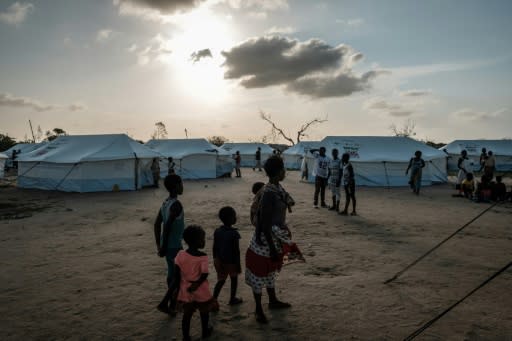 A mother stands with her children at an evacuation centre in Dondo, north of Beira, as authorities scramble to avert an epidemic after a devastating cyclone which killed more than 700 people and left countless thousands homeless