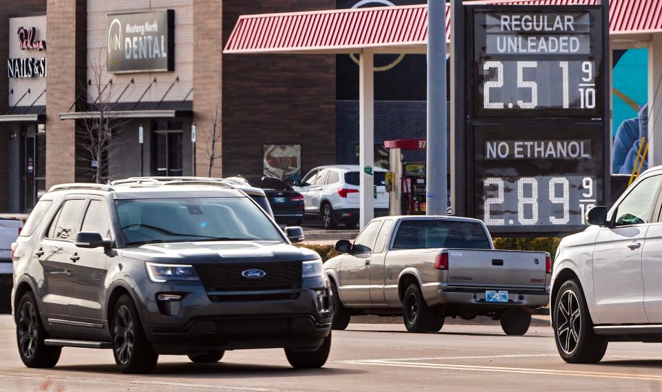 Cars drive by gas price signs on Friday in Yukon.