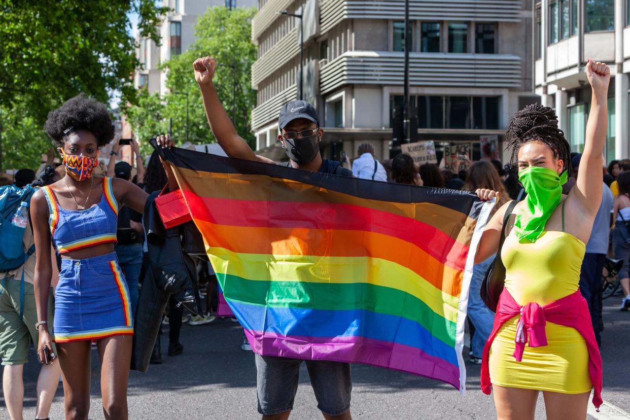 People hold a rainbow flag.