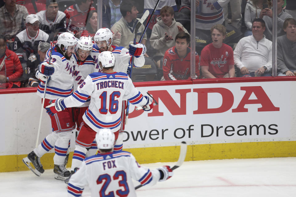 New York Rangers left wing Artemi Panarin, center, celebrates with teammates after scoring a goal during the third period in Game 4 of an NHL hockey Stanley Cup first-round playoff series against the Washington Capitals, Sunday, April 28, 2024, in Washington. (AP Photo/Tom Brenner)