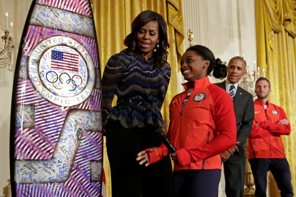 <p>2016 Olympic individual all-around gymnast Simone Arianne Biles presents a surf board to U.S. President Barack Obama and First lady Michelle Obama as he welcomes U.S. Olympic and Paralympics teams at the White House in Washington, U.S., September 29, 2016. REUTERS/Yuri Gripas</p>