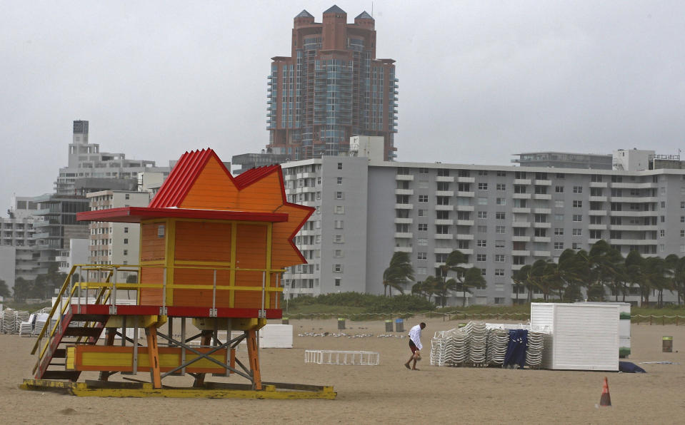 A man walks off the nearly abandoned Lummus Park Beach as a tropical storm warning was issued for the Miami Beach, Fla., area on Monday, Sept. 3, 2018. Tropical Storm Gordon lashed South Florida with heavy rains and high winds on Monday, forcing holiday beachgoers to drier ground. (Carl Juste/Miami Herald via AP)