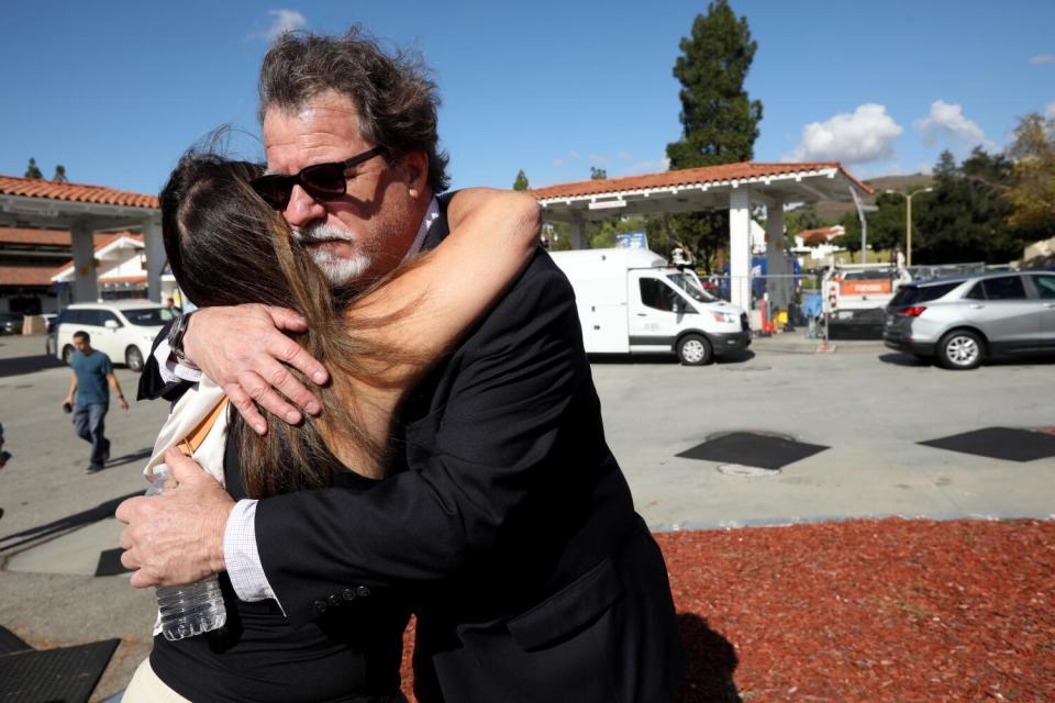 Two people hug outdoors.