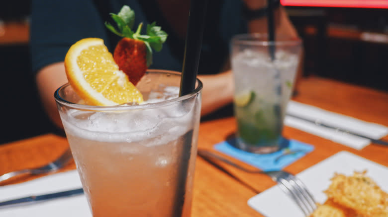 Pink drink with black straw and lemon