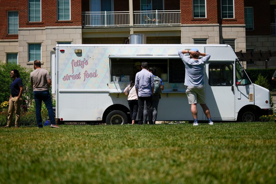 Diners order lunch from the Fetty's Street Food truck in the food court at the Columbus Commons.