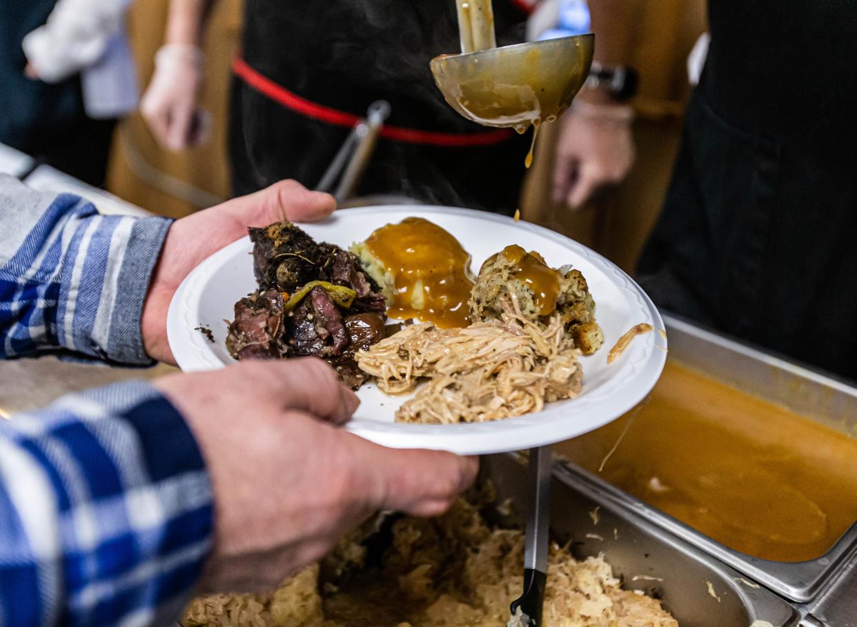 Volunteers load up a plate for a hungry diner during the 94th annual Tom McNulty Memorial Coon Feed at American Legion Post 196 in Delafield in 2020. The meal includes raccoon meat, turkey, potatoes, stuffing, sauerkraut, relishes and dessert. This year's event will be Jan. 29.