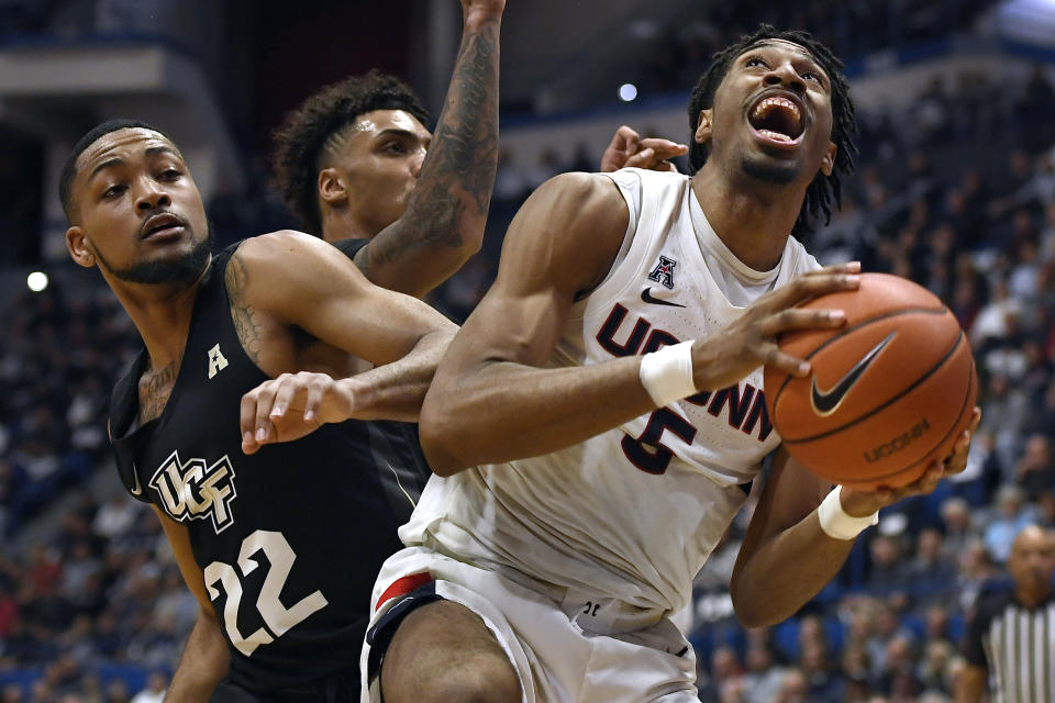 Connecticut's Isaiah Whaley (5) pulls down a rebound against Central Florida's Darin Green Jr.(22) in the first half of an NCAA college basketball game, Wednesday, Feb. 26, 2020, in Hartford, Conn. (AP Photo/Jessica Hill)
