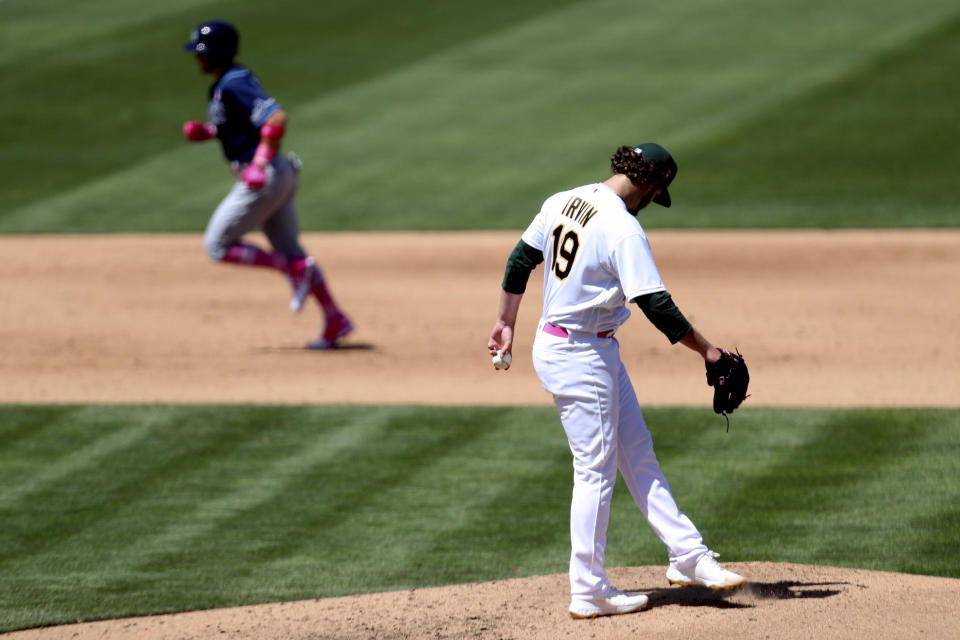 Tampa Bay Rays' Mike Brosseau, left, rounds the bases after hitting a solo home run against the Oakland Athletics' Cole Irvin, right, during the sixth inning of a baseball game in Oakland, Calif., Sunday, May 9, 2021. (AP Photo/Jed Jacobsohn)