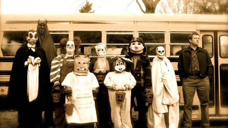 An image from Trick 'R Treat shows a group of children dressed in Halloween costumes in front of a school bus