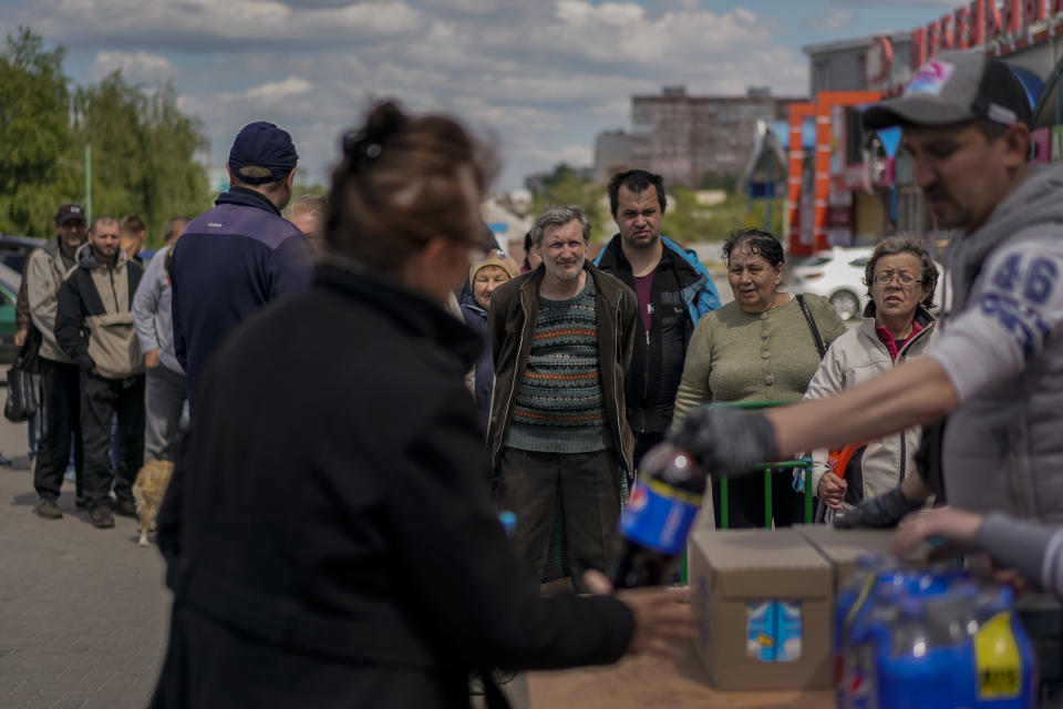 People queue to receive food donations in Kharkiv, eastern Ukraine, Thursday, May 19, 2022. (AP Photo/Bernat Armangue)