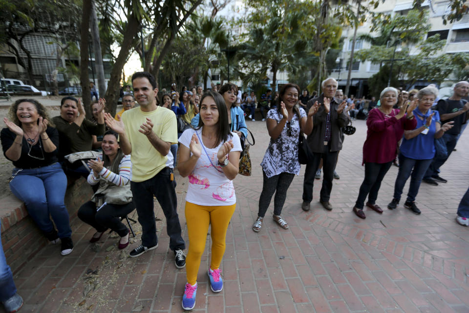In this Feb. 19. 2019 photo, volunteers applaud during a meeting for recruiting volunteers, at a square in Caracas, Venezuela. As President Nicolas Maduro prepares against a possible U.S. invasion deploying missiles and infantryman to the border, his opponents are readying their own troops: nurses, doctors, engineers and even homemakers who are among thousands of volunteers who've signed up to distribute humanitarian aid in the face of a government ban. (AP Photo/Fernando Llano)
