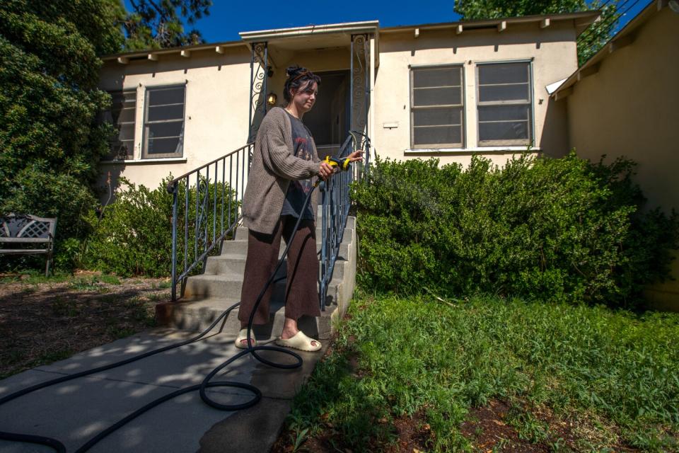 Alicia De Mello waters her front yard in in South Pasadena