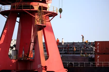 Men work on a cargo ship at a port in Lianyungang