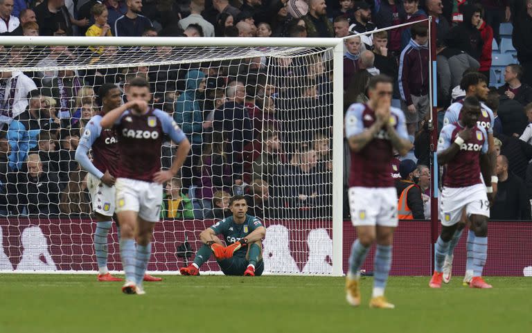 Emiliano Martínez, se sienta abatido después de conceder un tercer gol durante el partido de fútbol de la Premier League inglesa entre Wolverhampton y Aston Villa